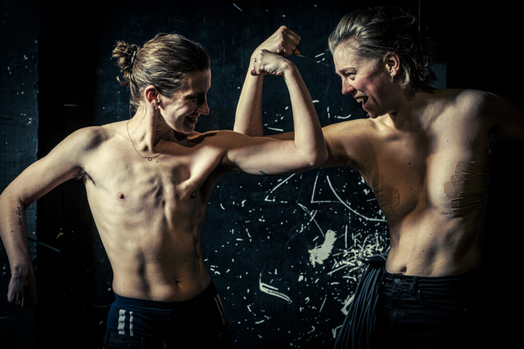 S. Rudat und Elina Ritzau lassen mit nacktem Oberkörper ihre Muskeln spielen