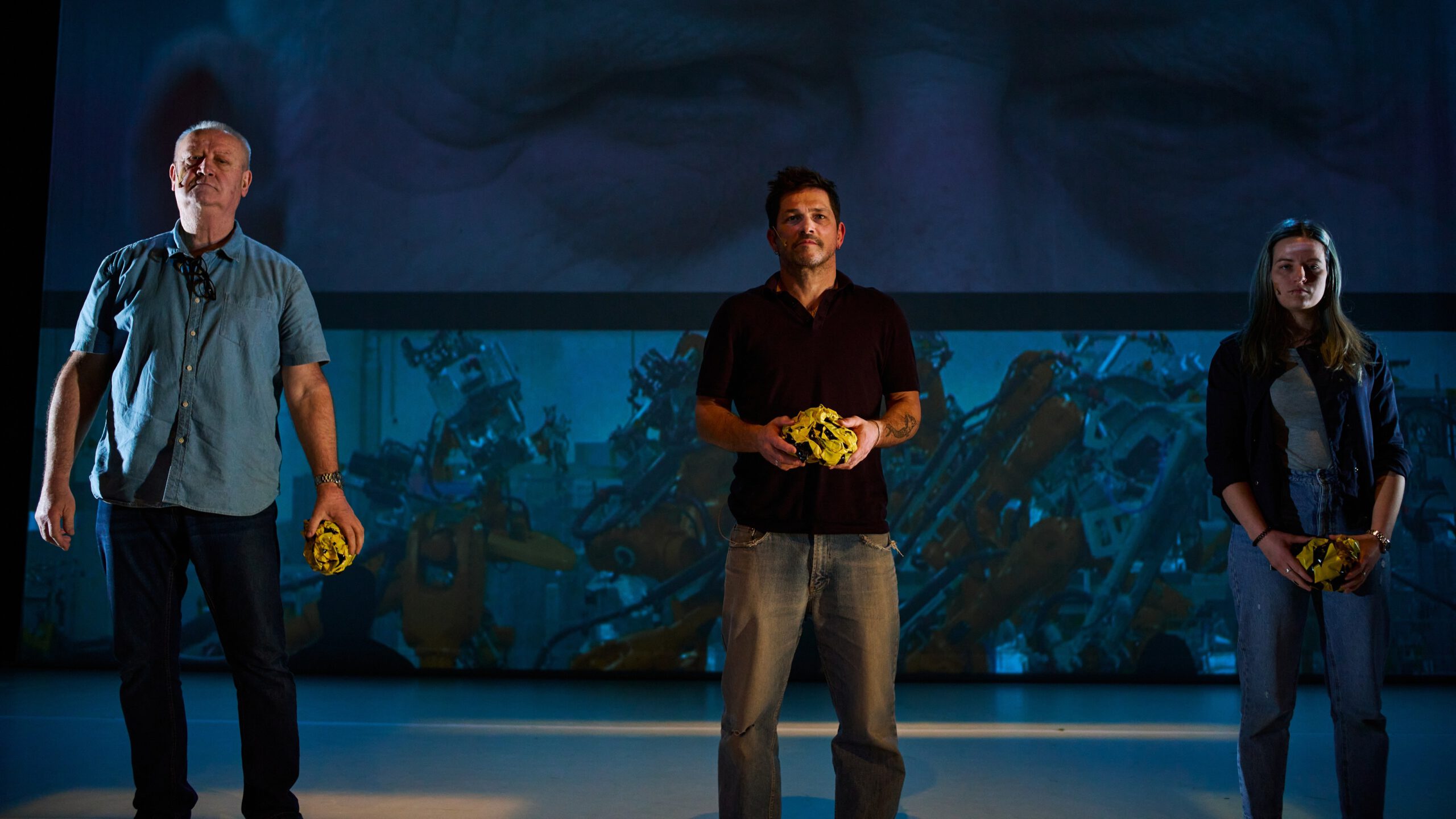 Drei Personen vor einer Videoprojektion